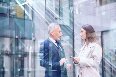 Reflection of man and woman standing on glass window