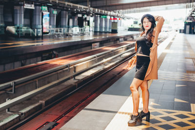 Full length portrait of woman at railroad station