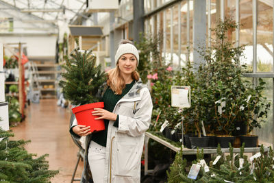 A woman buying a christmas norman tree in a shop