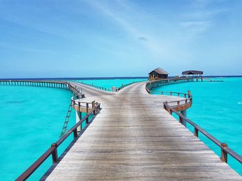 Pier over sea against blue sky