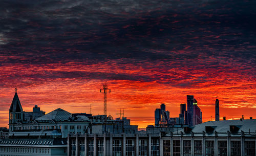 Buildings in city against sky during sunset