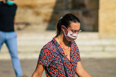 Portrait of young woman wearing sunglasses standing outdoors