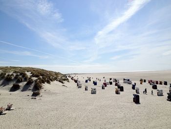 Hooded beach chairs against sky