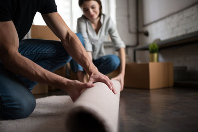 Midsection of couple sitting at home