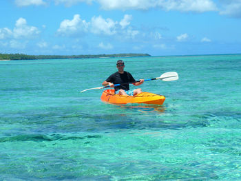 Man in boat on sea against sky