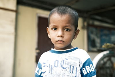 Portrait of boy standing against wall