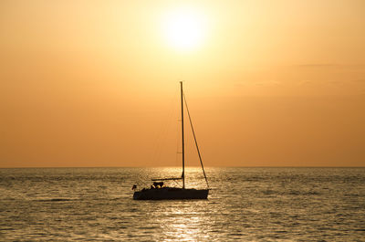 Boat sailing in sea at sunset