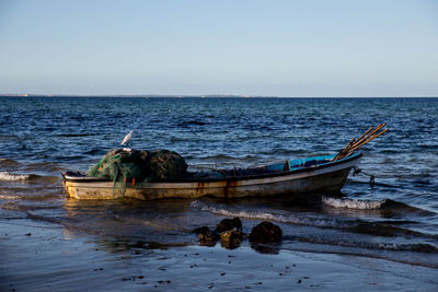 Boat moored on sea against clear sky