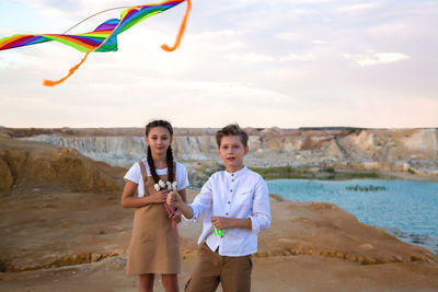 Children flying a kite in abandoned industrial quarry.