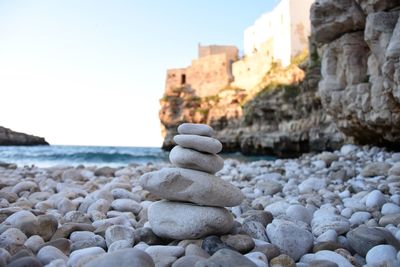 Stack of pebbles on beach against clear sky