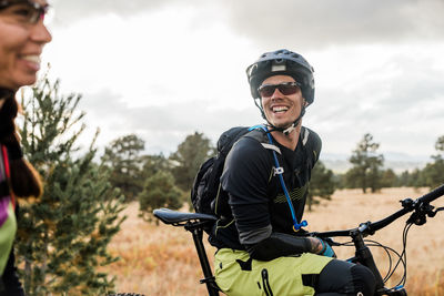 Lauging male mountain biker in meadow