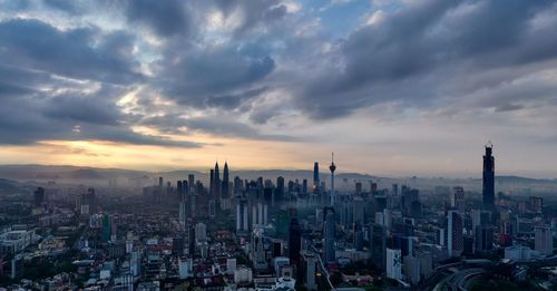 Aerial view of modern buildings in city against sky during sunset