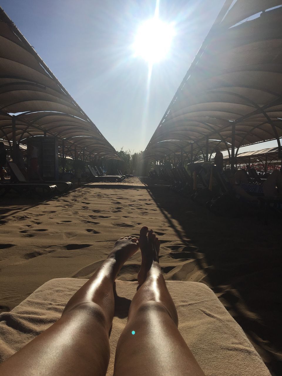 human leg, low section, sunlight, sun, real people, human foot, human body part, sunbeam, personal perspective, one person, lifestyles, women, relaxation, barefoot, leisure activity, day, sky, outdoors, close-up, adult, adults only, people