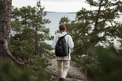 Rear view of woman walking at sea