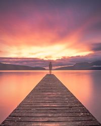 Pier on sea at sunset