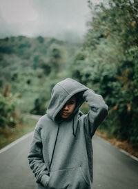 Man wearing mask standing in rain during rainy season