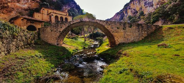 Arch bridge over water beside ancient church