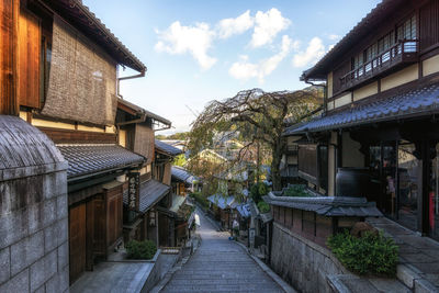Street amidst houses and buildings against sky