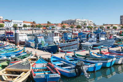 Boats moored at harbor against buildings in city