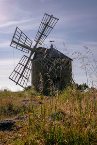 Traditional windmill on field against sky