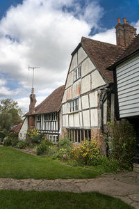 Exterior of old house by building against sky