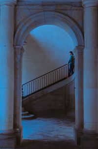 Man standing at bridge by building