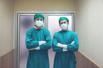 Portrait of a male surgeon in an operating room with a team of doctors in the background.