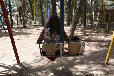 Woman sitting on tree trunk