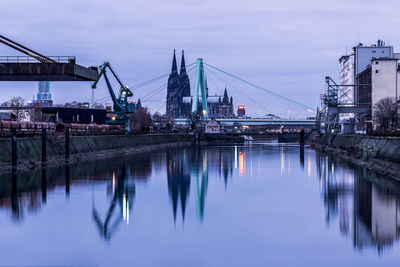 Reflection of bridge in river against sky