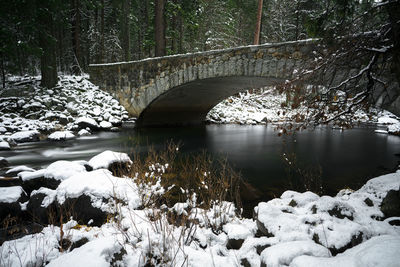 Bridge over river during winter