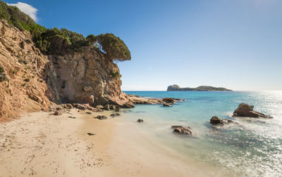 Scenic view of rock formations and sea against clear sky