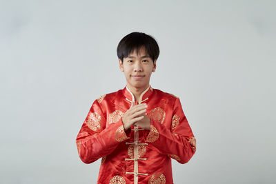 Portrait of smiling young man against white background