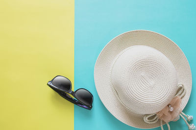 High angle view of sunglasses on hat against yellow background