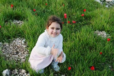 Portrait of girl standing on grassy field