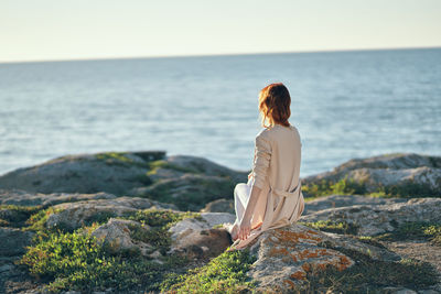 Rear view of woman looking at sea against sky