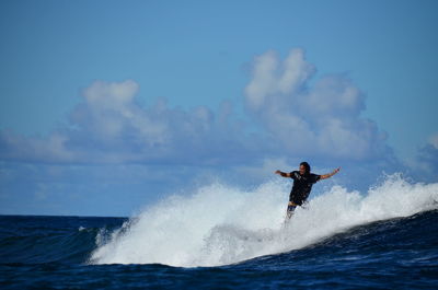 Man surfing on sea against sky
