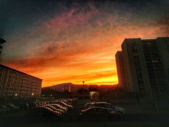 Cityscape against dramatic sky during sunset