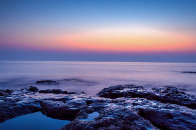 Scenic view of sea against sky at sunset