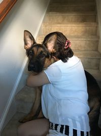 Woman with dog on stairs at home