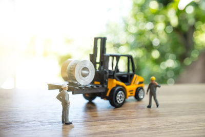 Close-up of figurines with toy forklift on table