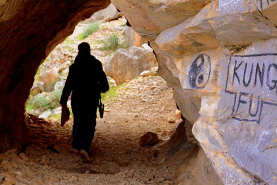 Rear view of man standing on rock