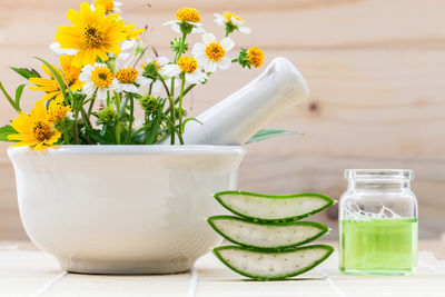 Close-up of flower in mortar and pestle by aloe vera