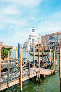 View of wooden posts in canal against sky