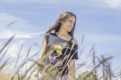 Young woman wearing mask on field against sky