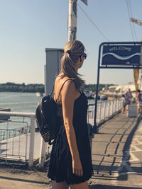 Woman standing in city against sky