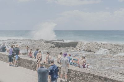 People at beach against sky