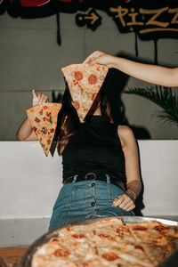 Midsection of woman holding pizza on table