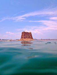 Rock formation on sea shore against sky