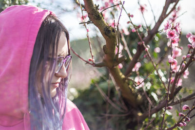 Portrait of woman with pink petals on tree