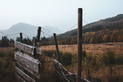 Fence on landscape against sky